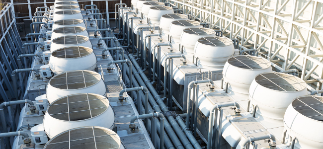 Vista aérea de una instalación con múltiples torres de refrigeración, mostrando una serie de unidades de enfriamiento organizadas